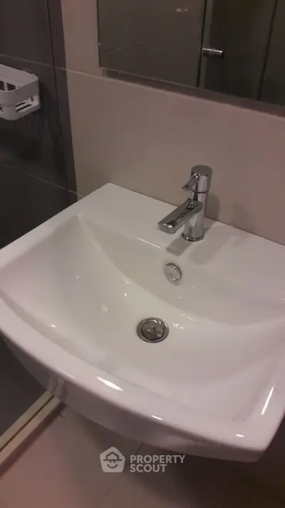 Modern bathroom sink with sleek design and chrome faucet in contemporary setting.