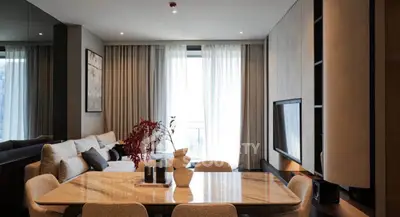 Elegant living room with modern decor and large dining table, perfect for entertaining.