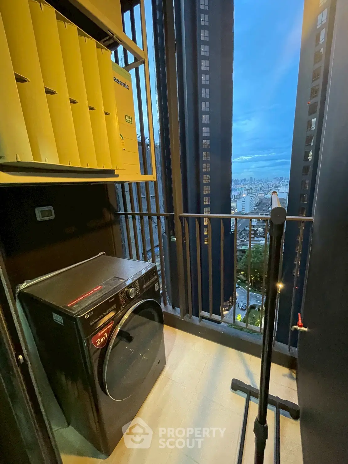 Modern balcony with washing machine and city view, perfect for urban living.