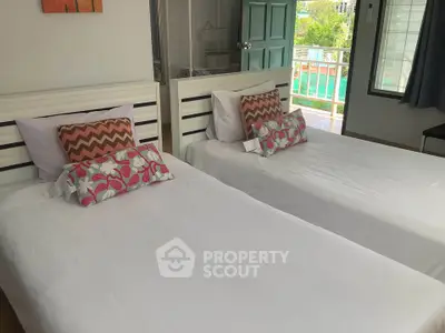 Bright twin bedroom with balcony access and stylish decor