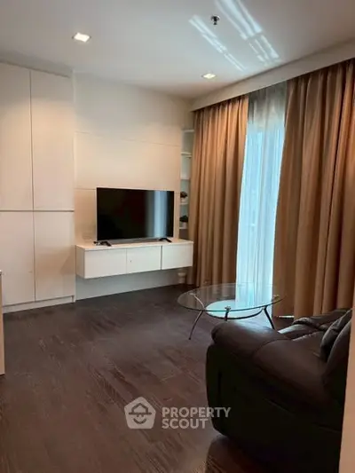 Modern living room with sleek furniture and large window for natural light.