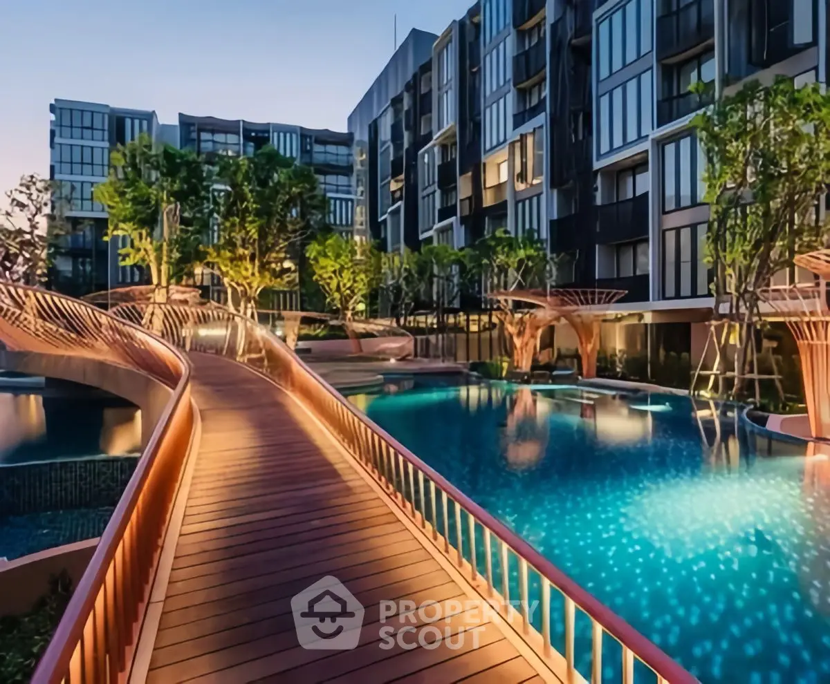 Luxurious modern apartment complex with stunning pool and landscaped gardens at dusk.