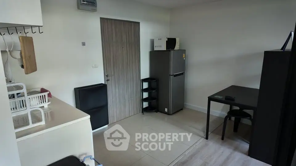 Modern apartment interior with kitchen and dining area, featuring sleek appliances and minimalist design.