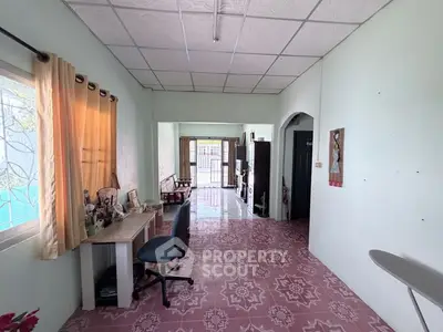 Spacious living area with unique tile flooring and ample natural light, perfect for comfortable living.
