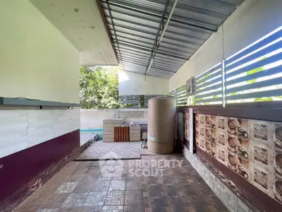 Spacious outdoor area with tiled flooring and partial roof, ideal for relaxation or entertainment.