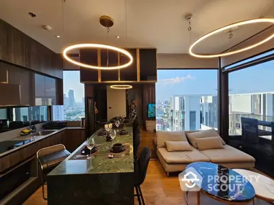 Luxurious open-plan living space with modern kitchen, chic lighting, and panoramic city views, perfect for upscale urban living.