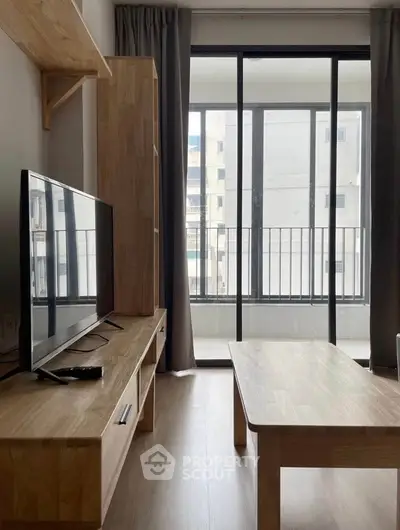 Modern living room with large windows and wooden furniture, offering a bright and inviting atmosphere.