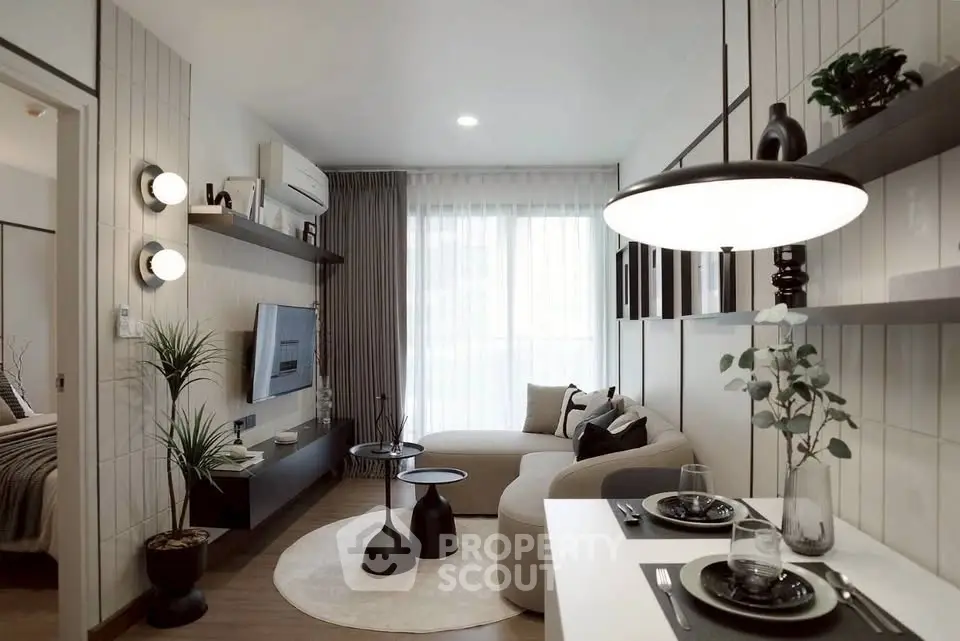 Modern living room with stylish decor and natural light, featuring a cozy sofa and sleek entertainment unit.