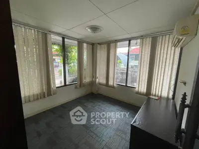 Cozy room with large windows and natural light, perfect for a home office or study area.