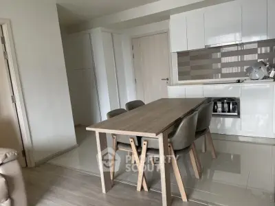 Modern kitchen with sleek cabinetry and dining area in contemporary apartment