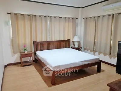 Spacious bedroom with wooden furniture and natural light