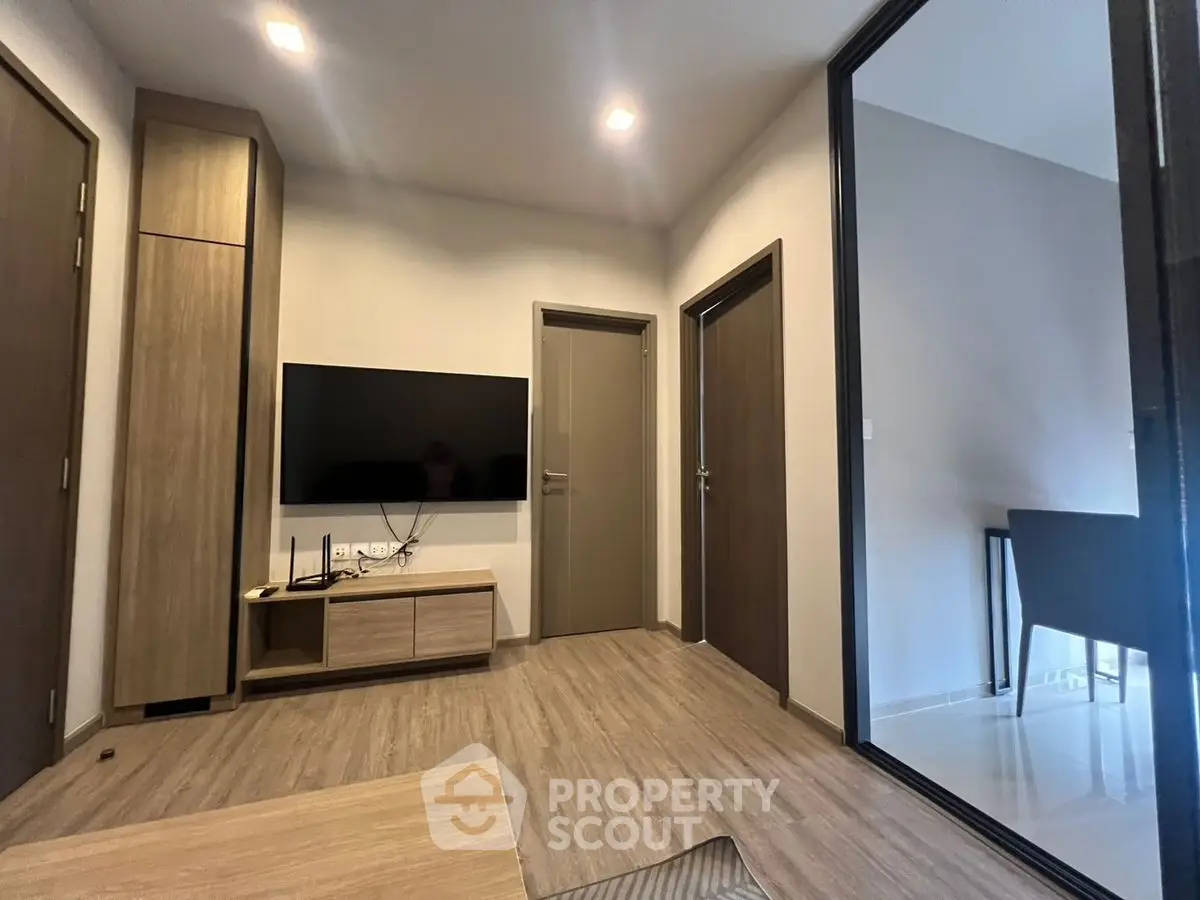 Modern living room with sleek TV setup and wooden flooring