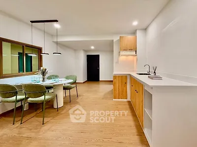 Modern open-plan kitchen and dining area with stylish wooden flooring and contemporary furniture.