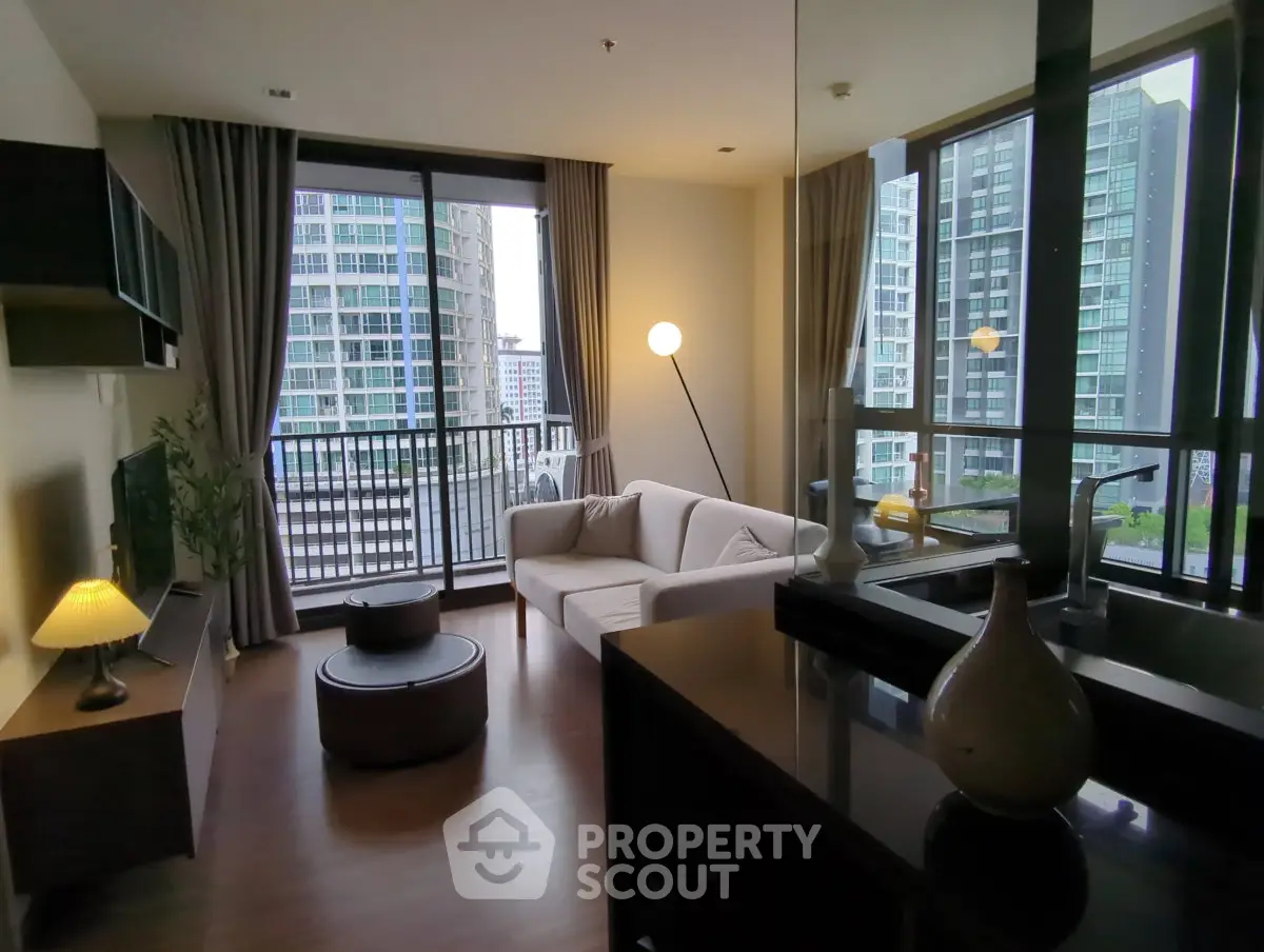 Modern living room with large windows and city view, featuring stylish furniture and elegant decor.