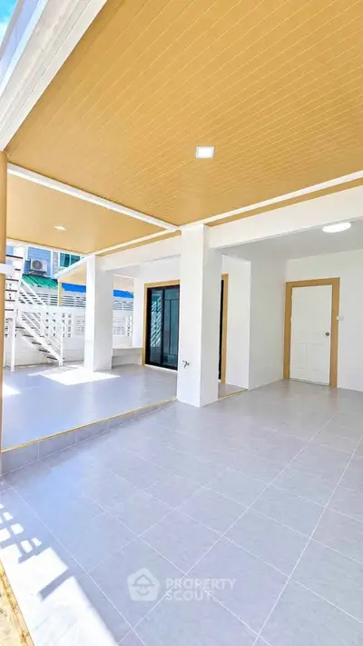 Spacious modern patio with elegant tile flooring and stylish ceiling design