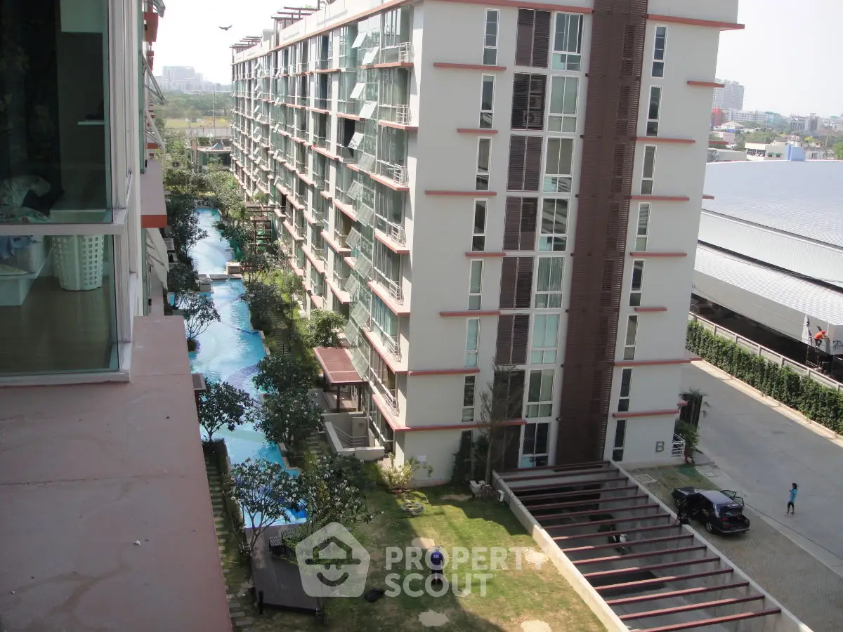 Modern apartment building with pool and garden view, showcasing urban living amenities.