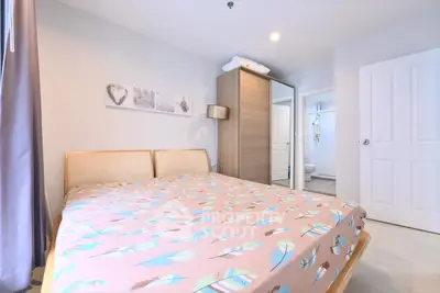 Spacious bedroom with modern decor and ensuite bathroom in a stylish apartment.