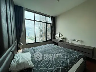 Modern bedroom with large window offering city view, featuring stylish decor and ample natural light.