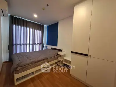 Modern bedroom with sleek design, featuring a cozy bed, stylish wardrobe, and elegant wooden flooring.