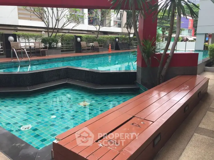 Luxurious outdoor pool area with modern design and lush greenery.