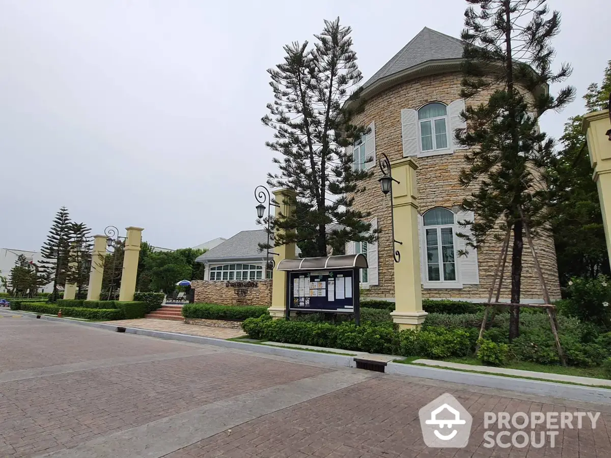 Elegant estate with manicured gardens, grand entrance, and towering pines, showcasing luxury living and timeless architecture for a discerning buyer.