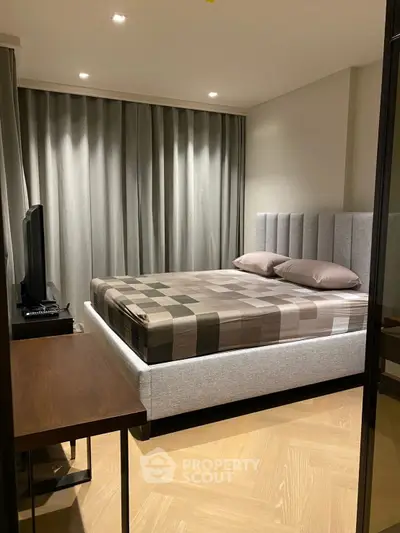 Modern bedroom with stylish decor and cozy ambiance, featuring a plush bed and elegant lighting.