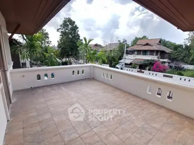 Spacious balcony with scenic view of residential neighborhood and lush greenery.