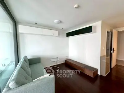 Modern minimalist living room with sleek furniture and large window.