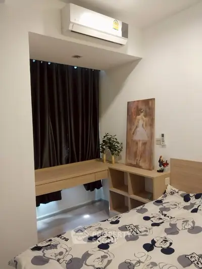 Cozy bedroom with modern decor and air conditioning, featuring a stylish bedspread and elegant artwork.