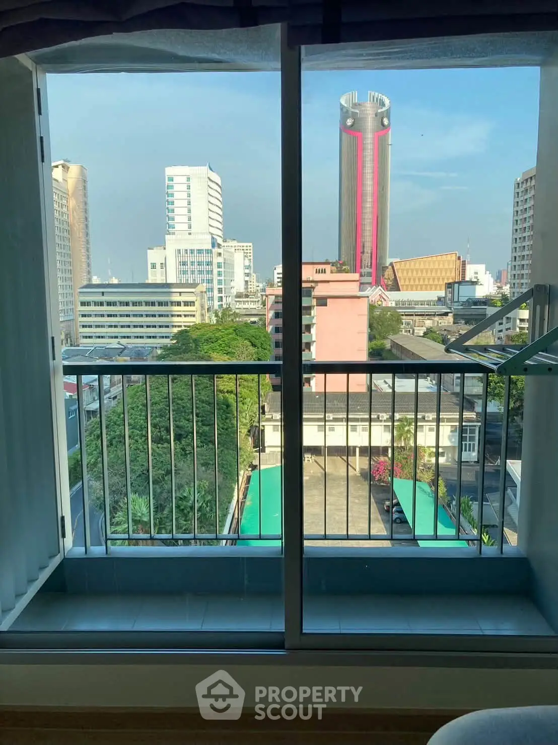 Stunning cityscape view from a modern apartment balcony, showcasing urban skyline and vibrant surroundings.