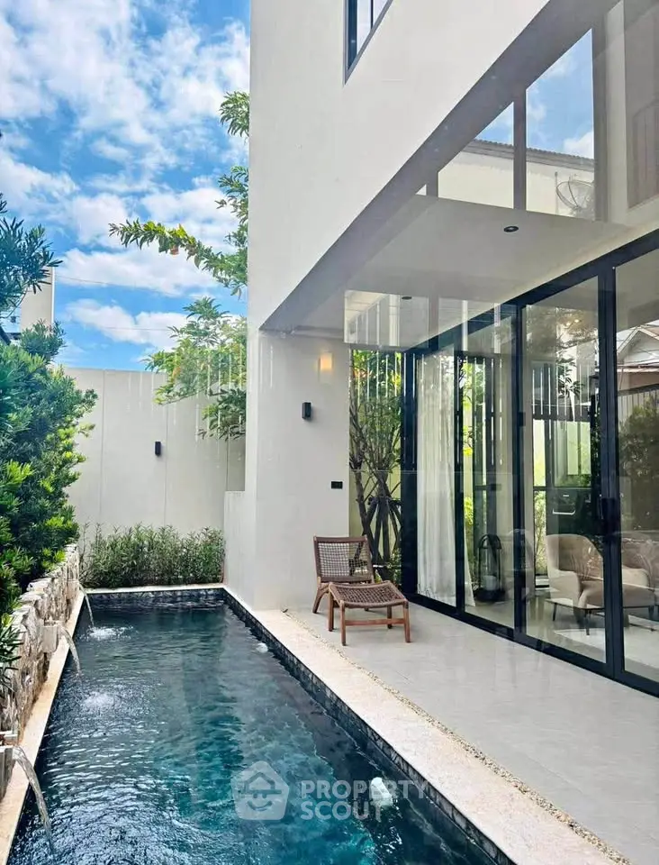 Luxurious modern home with private pool and glass doors, perfect for relaxation.