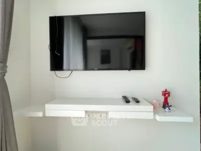 Modern living room with wall-mounted TV and sleek white shelves