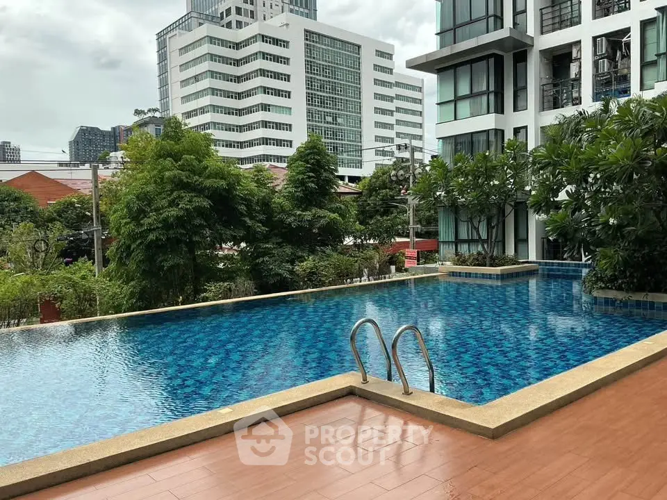 Luxurious apartment complex with a stunning outdoor pool and lush greenery, perfect for relaxation and leisure.
