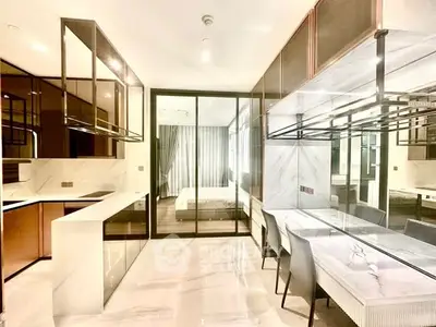 Modern kitchen with sleek design and open layout leading to a stylish bedroom.