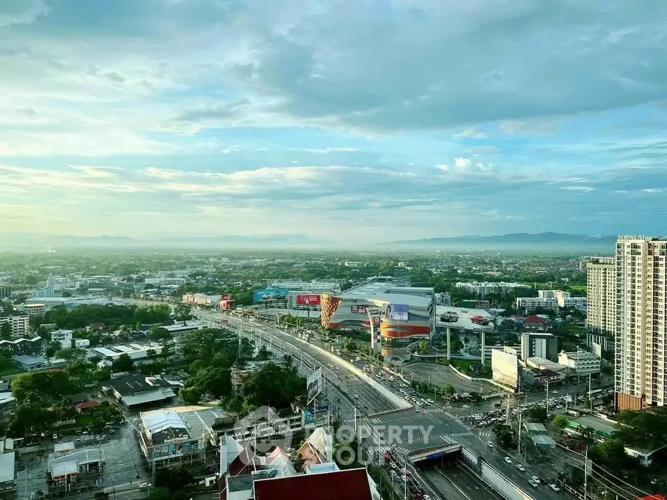 Stunning cityscape view from high-rise building showcasing urban landscape and distant mountains.