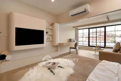 Luxurious bedroom with modern decor and large windows offering natural light.