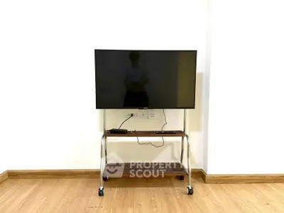 Modern TV stand with mounted flat-screen in minimalist room setting.