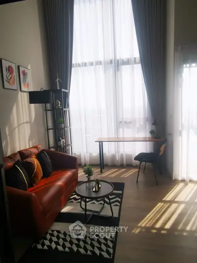 Modern living room with high ceilings, stylish decor, and large windows for natural light.