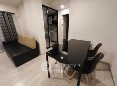 Modern living room with sleek black dining table and cozy sofa in stylish apartment.