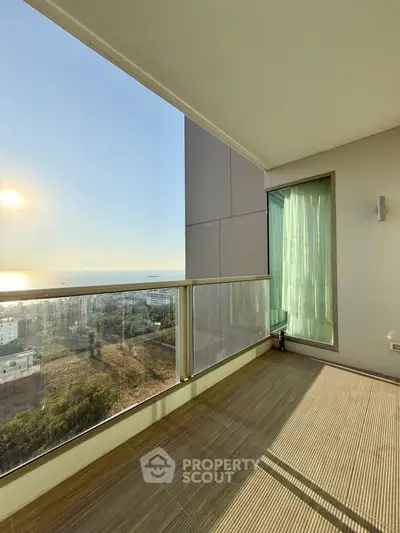 Spacious balcony with stunning ocean view and modern glass railing.