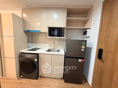 Modern compact kitchen with integrated appliances and sleek cabinetry in a stylish apartment.