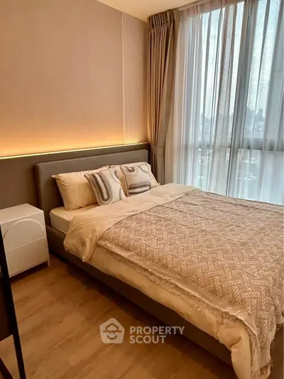 Cozy modern bedroom with large window and elegant decor