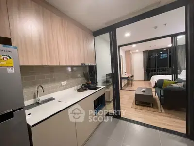 Modern open-layout kitchen with sleek design and cozy living area in a stylish apartment.