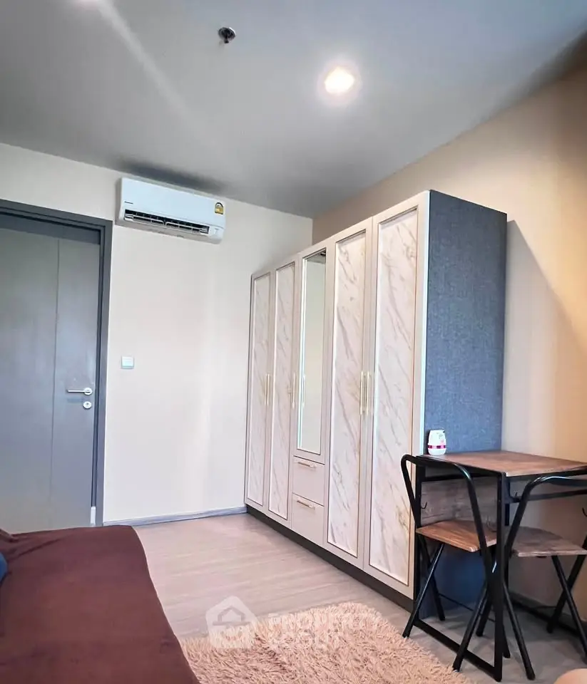 Modern bedroom with sleek wardrobe and cozy seating area