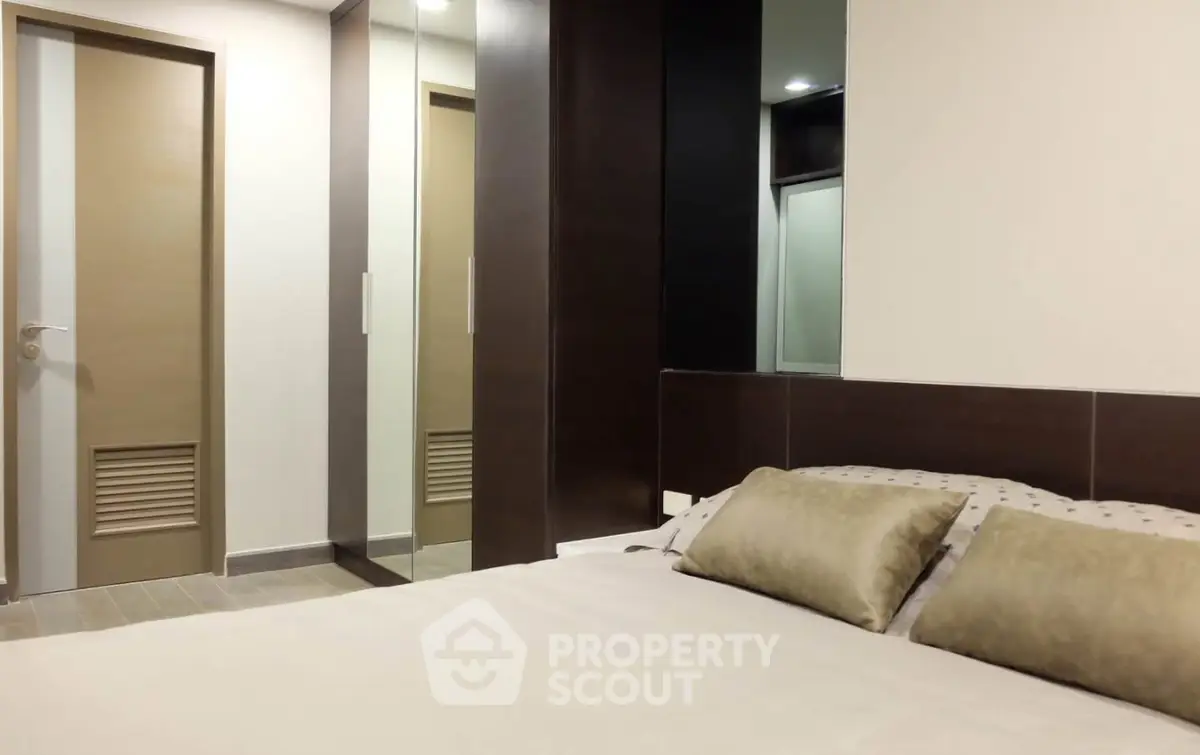 Modern bedroom with sleek design and mirrored closet doors