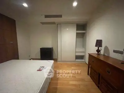 Spacious bedroom with wooden flooring and modern furniture