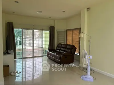 Spacious living room with sliding glass doors and modern furniture, ideal for relaxation and entertainment.