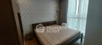 Spacious bedroom with large window and modern decor in a stylish apartment.