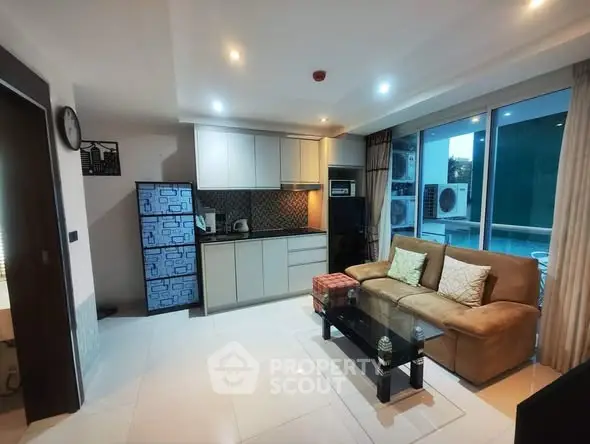 Modern living room with open kitchen and large windows for natural light.