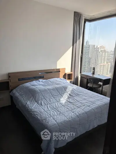 Modern bedroom with large window offering stunning city views